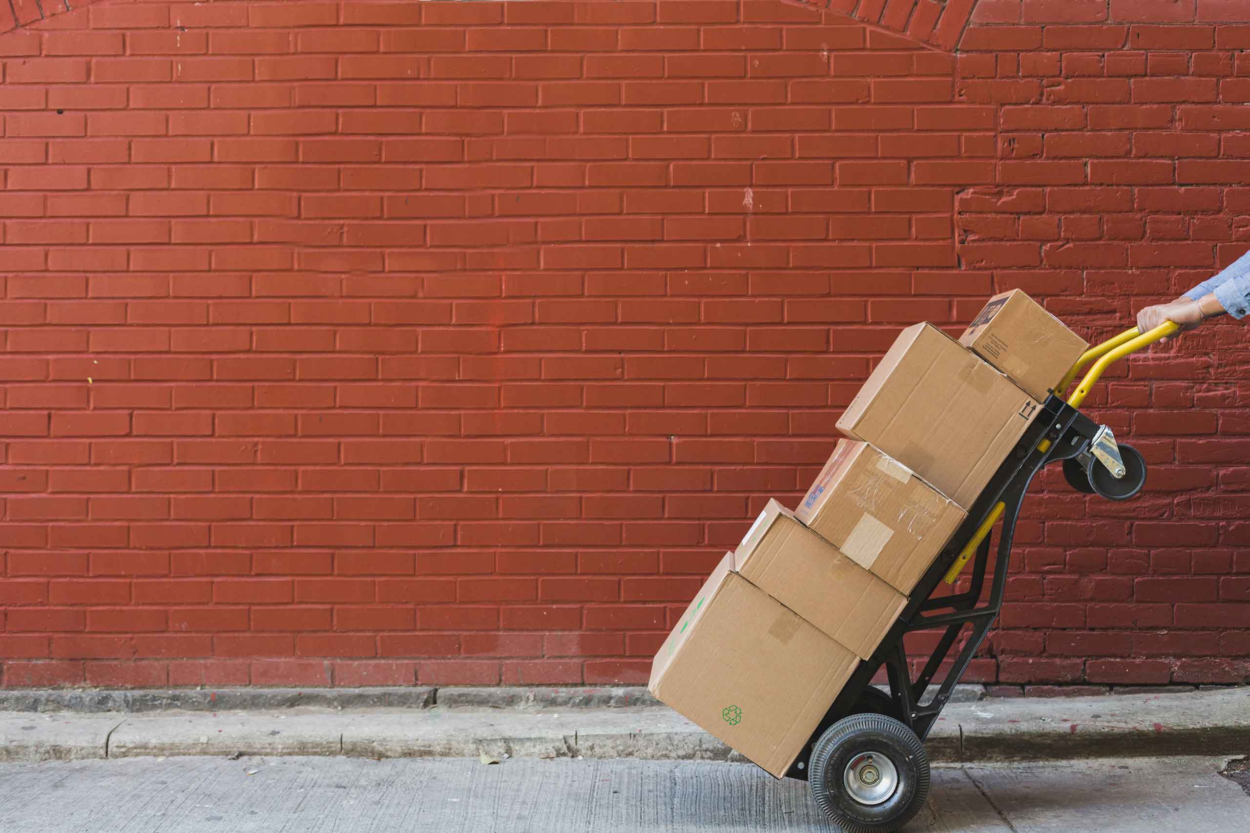 A stack of boxes being moved with a dolly cart.